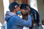 A young migrant couple embraces on the porch of St. Andrew's Parish House in Edgartown. Nearly 50 Venezuelans were flown to the island from Texas under what they said was a false pretense. Florida Gov. Ron DeSantis took credit for flying the immigrants to Massachusetts.