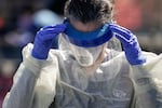 A medical professional from Children's National Hospital works at a coronavirus drive-through testing site on April 2, 2020, in Washington, D.C. She is wearing personal protective equipment, including a plastic face shield, gloves, a medical mask and coveralls.