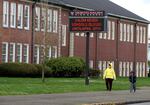 FILE: A woman and child walk past a North Salem High School in Salem, Ore., March 31, 2020, which like all schools in Oregon was closed at that time because of the coronavirus. In the Salem-Keizer School District, 81.5% of migrant students in the Class of 2022 graduated. That’s a more than 10-point increase from the previous year.