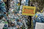 A climate activist holds a banner next to a plastic installation after marching to demand reductions in global plastic production ahead of negotiations in Kenya in November 2023.