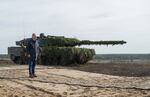 German Chancellor Olaf Scholz stands next to a Leopard 2 main battle tank of the German armed forces while visiting an army training center in Ostenholz, Germany, on Oct. 17, 2022.