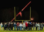 Students walk on the football field during a community prayer vigil, Tuesday, Nov. 14, 2023, at the Tuscarawas Valley Schools football stadium in Zoarville, Ohio.