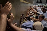 Muslim pilgrims touch the walls of the Kaaba, the cubic building at the Grand Mosque, during the annual Hajj pilgrimage, in Mecca, Saudi Arabia, Thursday, May 21, 2026.