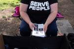 FILE - A volunteer immigration advocate holds copies of "know your rights" flyers featuring a hotline number for reporting ICE arrests outside the U.S. Immigration and Customs Enforcement building Tuesday, Sept. 9, 2025, in Portland, Ore.