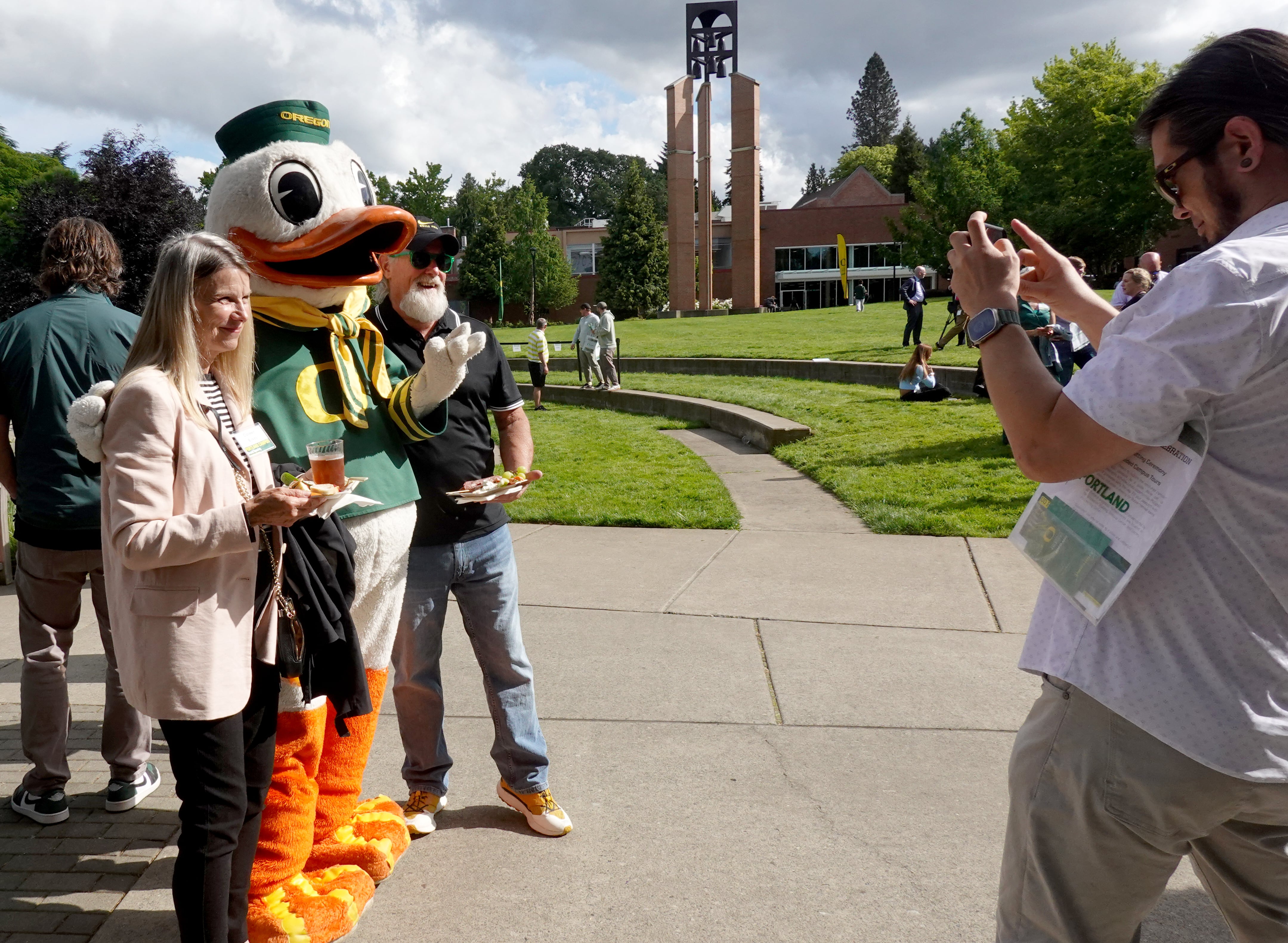 Guests at the grand opening of University of Oregon's Portland campus pose for photos with the UO mascot in Northeast Portland on May 29, 2025.