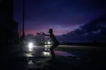 A woman prepares to catch a tossed frisbee during a massive blackout after a major power plant failed in Havana on Friday.