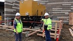 Dr. Lesley Ogden and Chris Lemar stand beside the backup generator at Lincoln City's new hospital, which is mounted on a shock-absorbing rack to protect against an earthquake. 