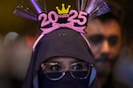 A woman stands near Petronas Twin Towers to watch the fireworks for the New Year's celebrations in Kuala Lumpur, Malaysia, Tuesday, Dec. 31, 2024. (AP Photo/Andy Wong)