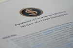 A report on cost cuts made by what's known as the Department of Government Efficiency on the Cabinet Room table at the White House on April 30, 2025.