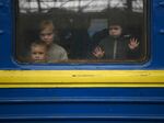 Children look out from a carriage window as a train prepares to depart from a station in Lviv, Ukraine, on March 3, 2022. The U.N. says more than 8 million Ukrainians fled to Europe since the start of the invasion.