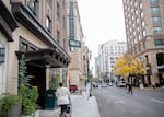 A woman walks past the Woodlark Building, home of the Woodlark Hotel, on Tuesday, Oct. 15, 2019, in downtown Portland, Ore. The Woodlark Hotel is part of the Gordon Sondland-founded Provenance Hotels chain. (Bryan M. Vance/OPB)