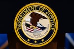 FILE - The U.S. Department of Justice seal is seen on a podium before a news conference, May 4, 2026, in Washington.