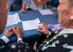 Mark Gallina, left, and Marx Phillips, right, sign marriage certificates with drag queen Poison Waters at “I Do at Darcelle” in Darcelle XV Plaza in Portland, Ore., on July 18, 2026.