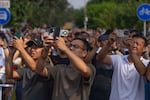 People use smartphones to film planes fly in formation during a military parade to commemorate the 80th anniversary of the end of World War II in Beijing on Wednesday.