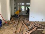 A volunteer from Texans On Mission rips up a damaged hardwood floor. Water from the Nolichucky River rose in the wake of Hurricane Helene and crossed a highway to flood this home near Jonesborough, TN.