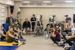 Injured soldiers at the Recovery rehabilitation center listen to Oleksandr Budko, a 28-year-old veteran, in Kyiv, Ukraine, on Oct. 18. During his visits to rehabs, soldiers ask Budko lots of practical questions about things like prosthetics and health care.