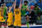 Oregon guard LJ Figueroa (12) passes around Iowa center Luka Garza (55) during the second half of a men's college basketball game in the second round of the NCAA tournament at Bankers Life Fieldhouse in Indianapolis, Monday, March 22, 2021.