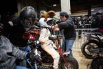 A worker affixes a camera to a racer's helmet before the costumed heat at the One Pro Race.