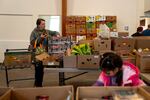 Elaine Leonard picks out plums as her daughter, 5-year-old Eliza Gamage, looks at other food at One Life Food Pantry, located in Real Life Foursquare Church in Vancouver, Wash., on Nov. 1, 2025.