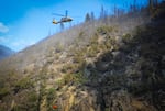 A helicopter delivers water to fight the Rum Creek Fire on Saturday.