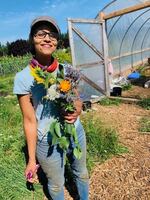 Mirabai Collins, co-founder and co-director of the Black Futures Farm in Southeast Portland, holds a bouquet of fresh flowers.