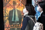 People walk by a poster to promote the movie "Oppenheimer" on Friday in Tokyo.