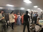 Students stand behind the scenes in costume at Haunt Camp in October 2022 in Enterprise, Oregon. After waiting in the line, visitors walked through a spooky restaurant scene, filled with community volunteers acting as patrons and a live pianist playing ragtime music.