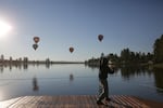 A man does tai chi as hot air balloons lift off over the lake at Big Summit Prairie in Central Oregon.