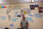 David Douglas High School social studies teacher and wrestling coach Scott Johnson poses with the deconstructed world map in his classroom. Johnson has been to 42 countries and encourages his students to travel and experience new cultures.