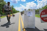 Greg Freeman, a National Park Service ranger closes the entrance gate due to the government shutdown at the Everglades National Park Shark Valley on Oct. 1 in Everglades National Park in Florida. Shark Valley remains open to visitors who park outside the entrance gate and walk in, although with limited staffing.