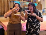 Author Stacey Mei Yan Fong, left, and OPB's Crystal Ligori eat pie at the Portland Book Festival in fall 2023. Ligori had made the Oregon Pear and Marionberry pie using Fong's recipe from her book, "50 pies, 50 states. An immigrant's love letter to the United States through pie."