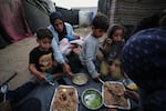 Displaced members of the Al-Zamli family break their fast on the first day of Ramadan inside their tent in Khan Younis, Gaza Strip, Wednesday, Feb. 18, 2026.