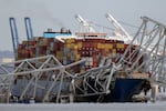 A container ship rests against wreckage of the Francis Scott Key Bridge on Tuesday, March 26, 2024, as seen from Pasadena, Md. The ship rammed into the major bridge in Baltimore early Tuesday, causing it to collapse in a matter of seconds and creating a terrifying scene as several vehicles plunged into the chilly river below.