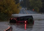 A couple waits for a rescue crew after their car got stuck in deep floodwaters in Windsor, California.