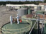 Workers with the U.S. Environmental Protection Agency stand atop a tank at the J.H. Baxter wood treatment facility in Eugene, Ore., in an undated photo provided by the EPA. Federal officials say cleanup at J.H. Baxter will take up to a year.