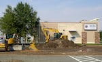Heavy equipment rests among piles of dirt  in front the offices for Nixyaawii Community Financial Services.