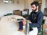 Sam Freni-Rothschild runs the homelessness prevention program at the nonprofit, Path Home. Freni-Rothschild sits in an office at Path Home and scrolls through emails on his work laptop.