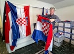 Ted Kaye holds a Croatian flag, part of his collection of over 500 flags.  “Flags are my tourist mementos, and I have two rules for my collection,” he said. “The first is I have to have been to the place in order to own the flag. And the second rule is the flag itself has to come from that place.”