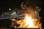 A protester sits where an elk statue used to stand during protests against racism and police violence in Portland, Ore., on July 16, 2020.