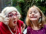 Six-year-old Lila shows off the fresh gaps where two her baby teeth used to be, while visiting with Sandra Claus in Bend.