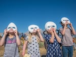 A group of children don eclipse glasses to watch the 2017 solar eclipse at Grand Tetons National Park in Wyoming.