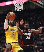 Los Angeles Lakers forward LeBron James, left, shoots Wednesday, Feb. 9, 2021 as Portland Trail Blazers forward Justise Winslow, one of several new players on the roster after the team made a recent flurry of trades. The Trail Blazers won 107-105.