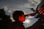 A youth looks through a telescope during a stargazing and comet-watching gathering at Joya-La Barreta Ecological Park in Queretaro, Mexico, on Oct. 19, 2024.