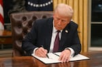 President Trump signs an executive order in the Oval Office on Inauguration Day.