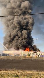 A fire at an abandoned Kmart in Northeast Portland, Ore., sends up a large plume of smoke Wednesday, July 19, 2023.