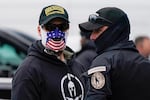 People wearing hats and patches indicating they are part of Oath Keepers attend a rally at Freedom Plaza Tuesday, Jan. 5, 2021, in Washington, in support of President Donald Trump.