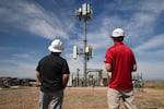 Workers observe a tower where Pano AI cameras are installed for detecting wildfires Monday, April 20, 2026, in Aurora, Colo.