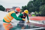 In this file photo, workers install solar panels, which will generate renewable energy. That energy is key to the transition to a sustainable energy system and adapting to the changing climate, say policy makers and activists responding to the climate crisis.
