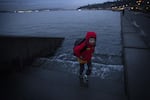 Ely Thomas, 7, runs from water spilling over stairs during a King Tide at Alki Beach Park on Friday, January 5, 2018, in West Seattle. 