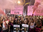 Protesters hold signs and smoke torches  during a demonstration calling for an hostages deal and against Israeli Prime Minister Benjamin Netanyahu and his government on August 10.